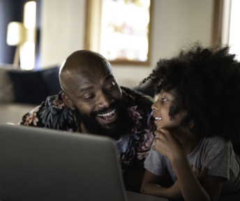 A father and child working on a laptop