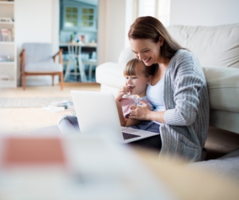 A mother and child working on a laptop